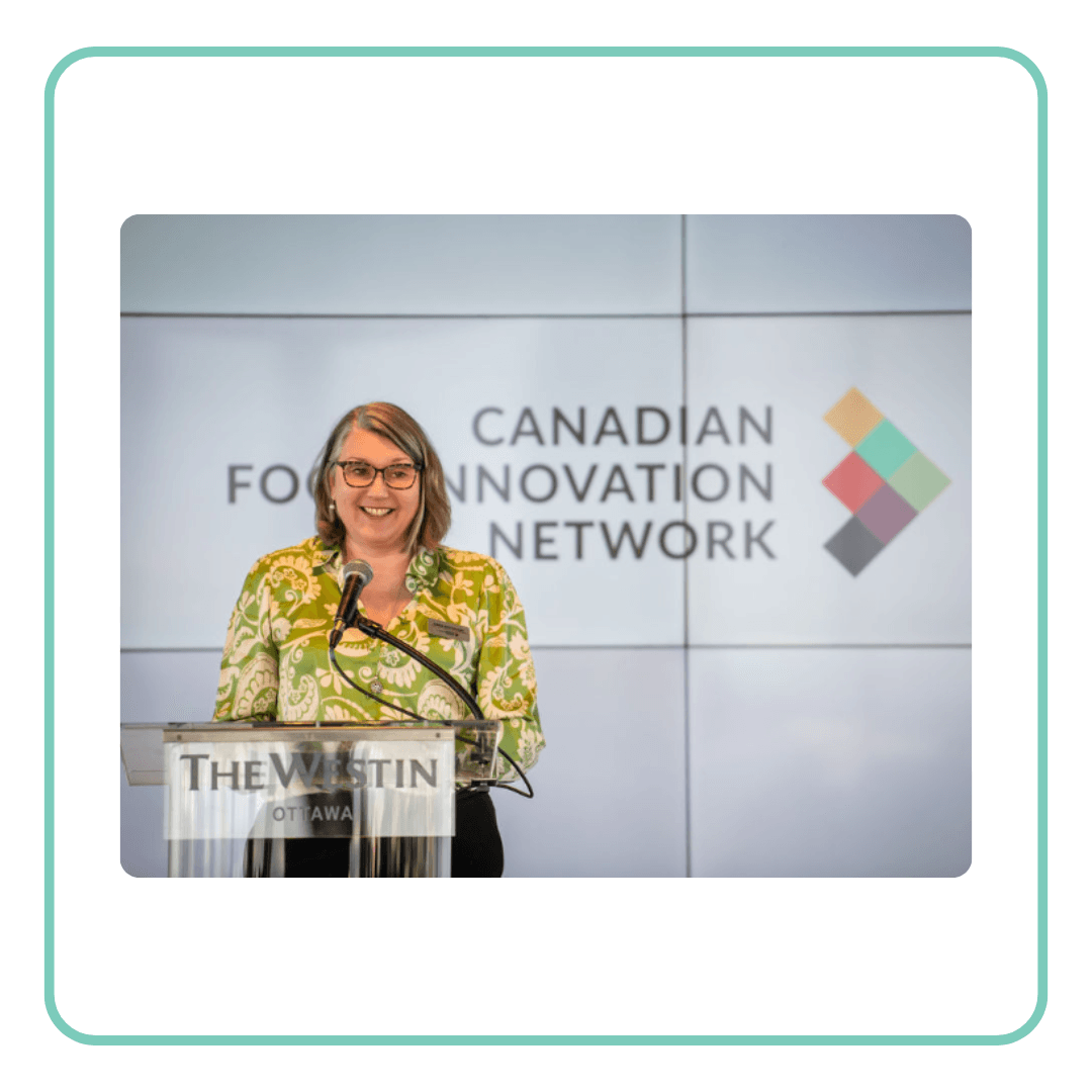 Woman speaking at podium with 'Canadian Innovation Network' on screen behind her.