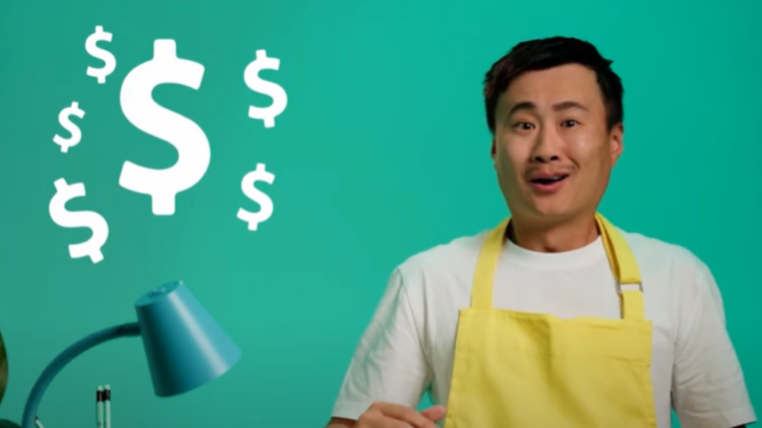 Man in yellow apron looks surprised with dollar signs floating around him.