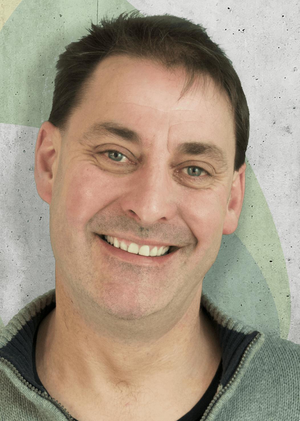 A smiling man with short dark hair looks directly at the camera.
