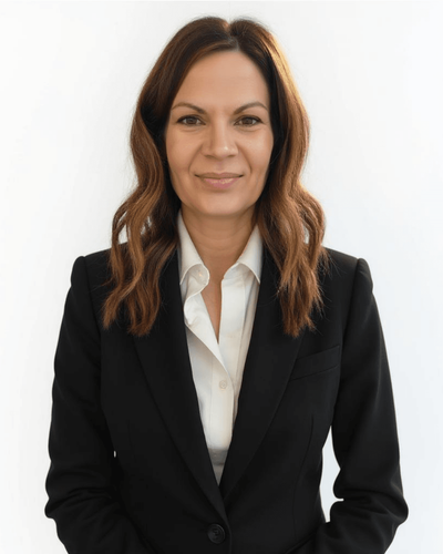 Professional woman with long brown hair wearing a black suit jacket and white shirt.